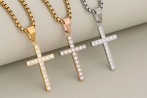 Detailed view of cross pendants in gold, rose gold, and silver finishes with CZ stones
