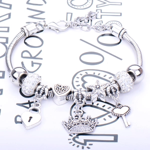 Silver snake chain bracelet with star, heart, crown, and key charms for women