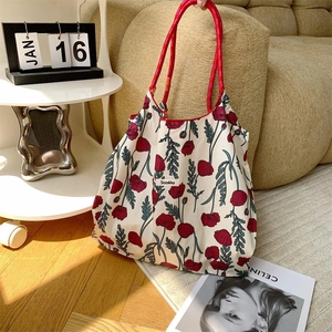 Detail of floral tote bag with red poppy patterns and sturdy woven rope handles