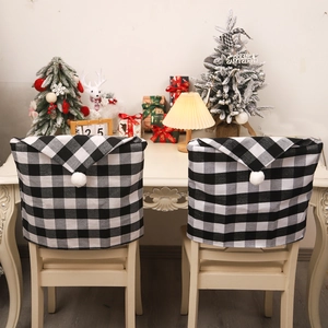 Christmas chair covers with black and white plaid pattern and plush pom poms in home setting