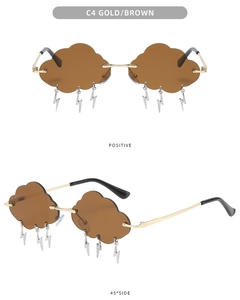 Detail view of gold cloud sunglasses with brown lenses and hanging lightning bolt charms
