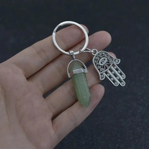 Detailed close-up of a Hamsa Hand keychain with a green hexagonal crystal pillar pendant