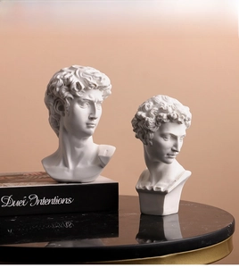 Close-up of David and Greek resin statues on a marble surface for art and decor