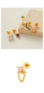 Detail of gold cartilage studs with pink heart, zircon accents, and screw back closures