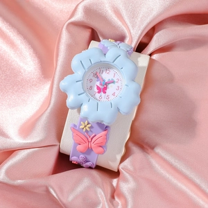 Close-up of blue flower dial children's watch with butterfly strap on pink silk
