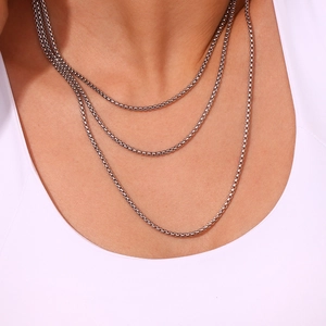 Minimalist silver stainless steel box chain necklace shown in multi-layered style