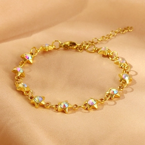 Gold stainless steel star bracelet with iridescent zircon stones on champagne satin fabric