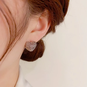 Detail of silver heart hoop earring with hollow mesh pattern shown on a model