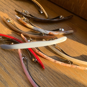 Close-up of minimalist acetate hair clips with metal spring clips on wood background