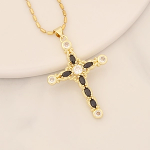 Detailed macro view of 18K gold cross pendant with black zircon and clear crystals