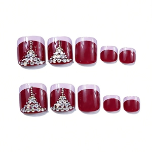 Macro view of burgundy square press-on toe nails with French tips and crystal rhinestones