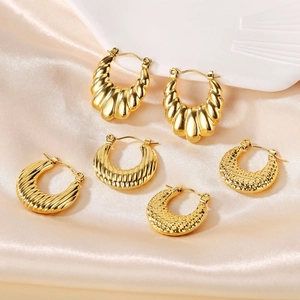 Trois paires de créoles vintage plaquées or 18k en acier inoxydable sur fond satiné