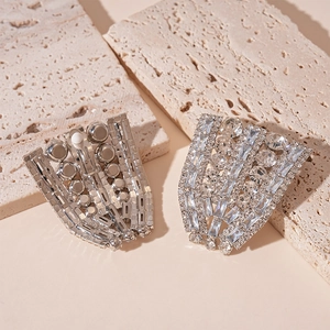 Detailed macro view of fan-shaped silver clip-on earrings with zircon stone inlay