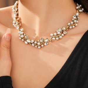 Close-up of vintage necklace with gold beads, pearls and diamonds on a model neck