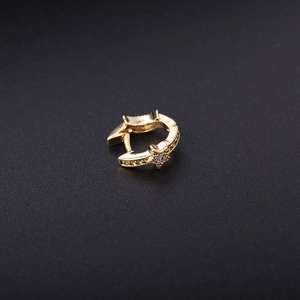 Detailed view of a gold star-shaped ear cuff with embedded small cubic zirconia stones