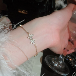 Detailed close-up of a golden butterfly bracelet with shimmering zircon stones on wrist