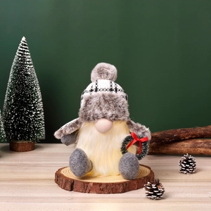 Detail eines leuchtenden Weihnachtsgnoms auf Holzscheibe mit festlicher Dekoration