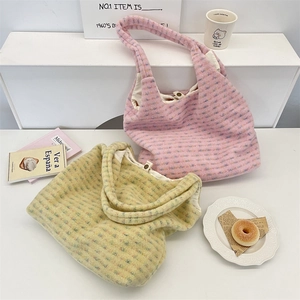 Detail of plush tote bags with spotted texture in pink and beige on a stylish white desk