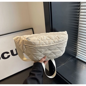 Detail of beige quilted crossbody bag with diamond patterns and silver zippers
