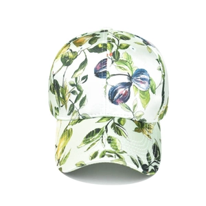 Close-up of baseball cap featuring vibrant lemon and leaf print on white satin fabric