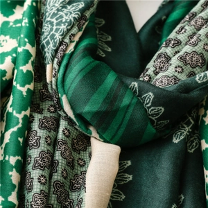 Detail shot of soft green floral linen scarf showing fine fabric texture and pattern
