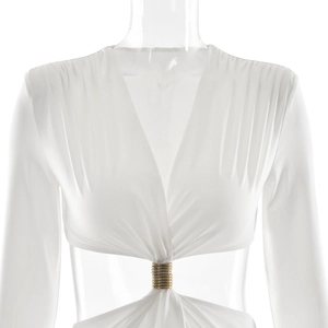 Detail of deep V-neckline and golden metal ring hardware on a white long sleeve dress