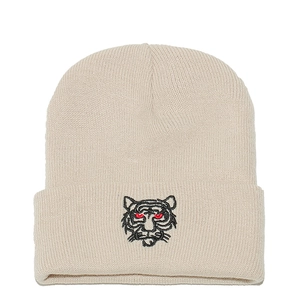 Close-up of tiger head embroidery on a beige ribbed knit beanie for winter