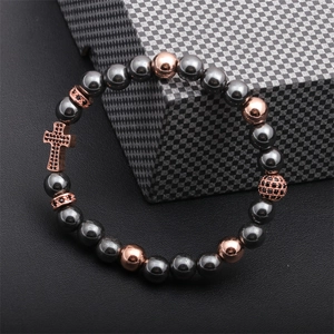 Detail of beaded cross bracelet with hematite beads and rose gold micro-pave accents