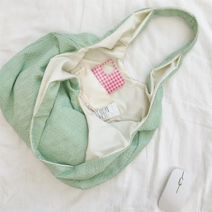 Detail of mint green pleated tote bag interior pocket and textured crinkle fabric