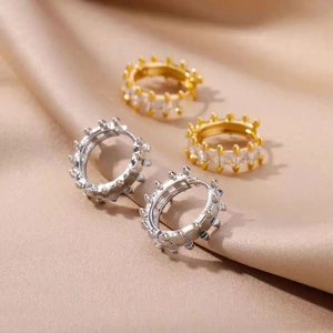 Detail of 18k gold and silver hoop earrings with rectangular zircon and punk spikes