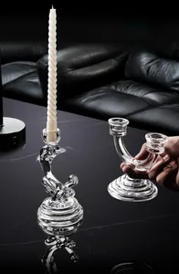 Detail van elegante glazen kandelaars met dolfijn en U-vormig ontwerp op een marmeren tafel