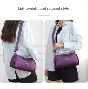 Detalle de bolso bandolera de nailon morado con correa ajustable y cremallera en modelo