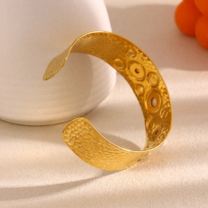 Detailed view of hammered 18K gold plated wide cuff bracelet with pearl inlay and ring texture