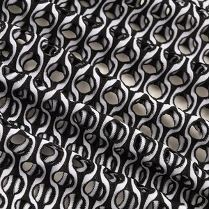 Détail du tissu en maille rayée noir et blanc avec motif géométrique pour maillots de bain