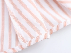 Detailed macro shot of orange striped fabric texture and high-quality hem stitching