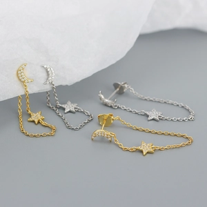 Macro shot of 925 sterling silver moon and star earrings with cubic zirconia and chain