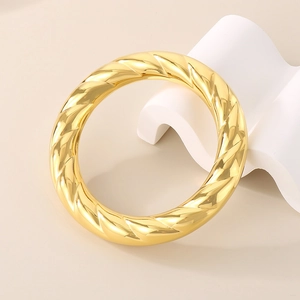 Polished 18k gold plated stainless steel chunky spiral twisted bangle on white stand