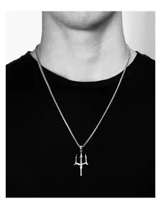 Macro shot of a silver trident pendant necklace worn on a black shirt for a gothic hip-hop style