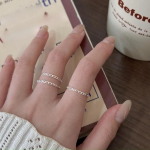 Close-up of triple hollow heart 925 sterling silver ring worn by a model in a cozy setting