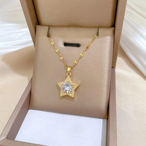 Detail of gold star pendant necklace with cubic zirconia on elegant satin background