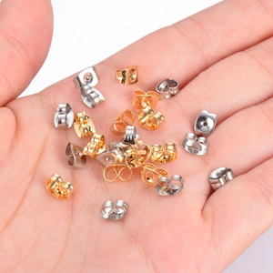 Mixed gold and silver butterfly earring backs made of stainless steel held in hand