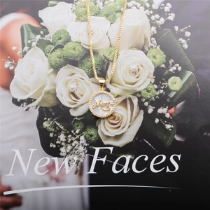 Gold Mom necklace with pearl zircon pendant on white rose magazine background