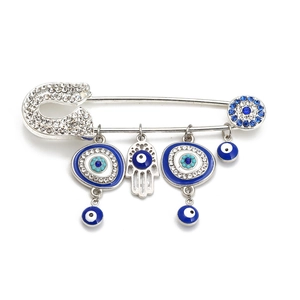Detailed close-up of silver Evil Eye and Hamsa Hand charms on a sparkling rhinestone brooch