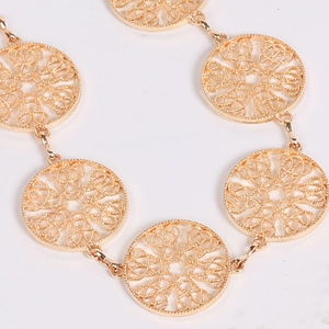 Macro shot of gold hollow circular metal links detailing the dress waist chain design