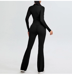Slim fit black yoga top with stand collar and flared sports pants back view showing cut