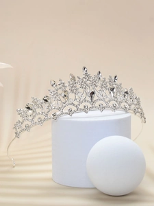Exquisite silver bridal crown with crystals on a modern white geometric display stand