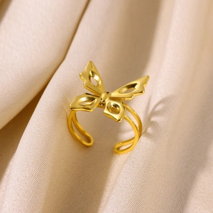Macro detail of golden open ring featuring a double-band design and butterfly charm