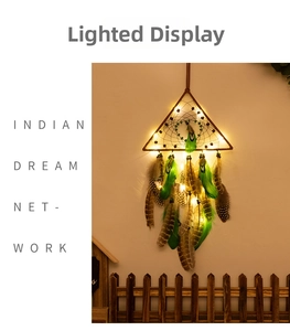 Detail of triangular LED dream catcher with green feathers and warm glowing lights