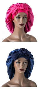 Detailed texture of satin sleep caps featuring large bows in rose red and navy blue