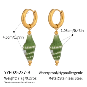 Detail view of gold stainless steel conch earrings with green ceramic shell charms